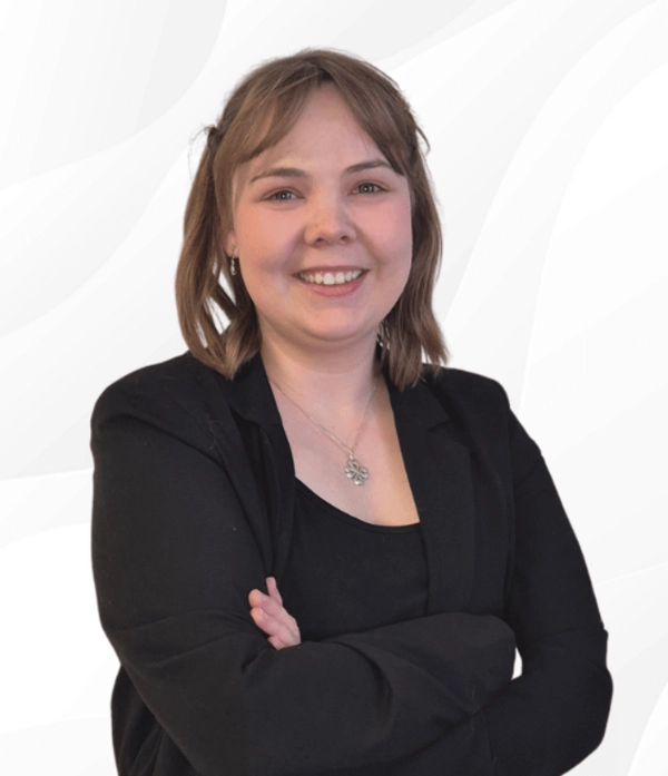 Lara Hinrichsen, Kundenbetreuerin bei PSW TRAINING, lächelt mit verschränkten Armen in schwarzer Kleidung vor hellem Hintergrund.