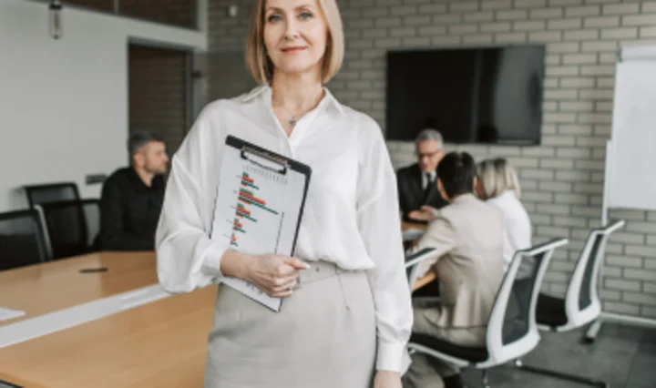 Lead-Auditorin nach ISO 27001 mit Audit-Checkliste im Besprechungsraum als Symbol für Leitung und Durchführung eines Informationssicherheitsaudits.