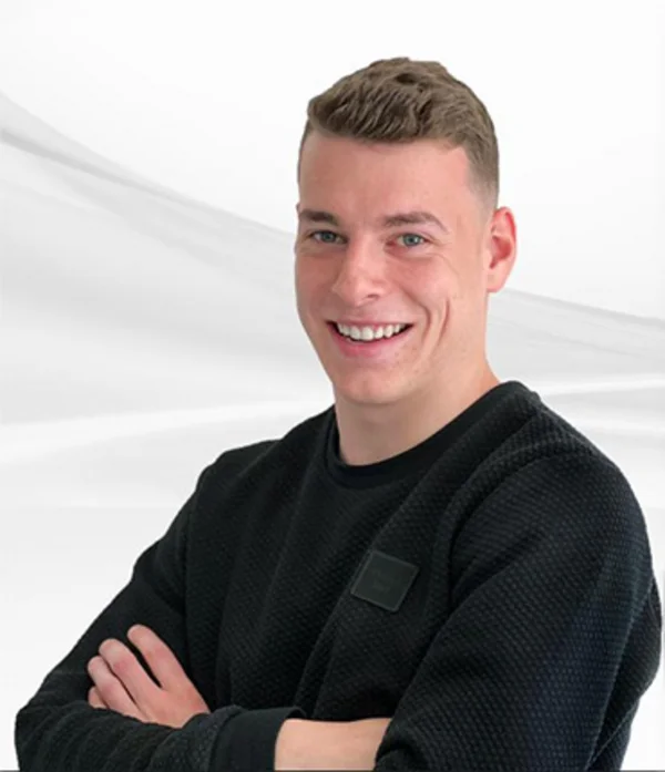 Silas Holzhauer, Mitarbeiter der PSW Training, mit verschränkten Armen und freundlichem Lächeln vor hellem Hintergrund.