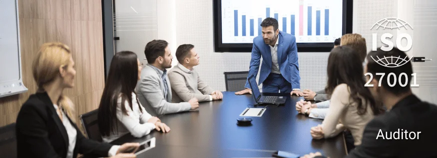 Personengruppe im Konferenzraum mit Präsentation im Hintergrund, ISO 27001-Siegel eingeblendet – Darstellung für ISO 27001 Auditor Training im Bereich Informationssicherheit.