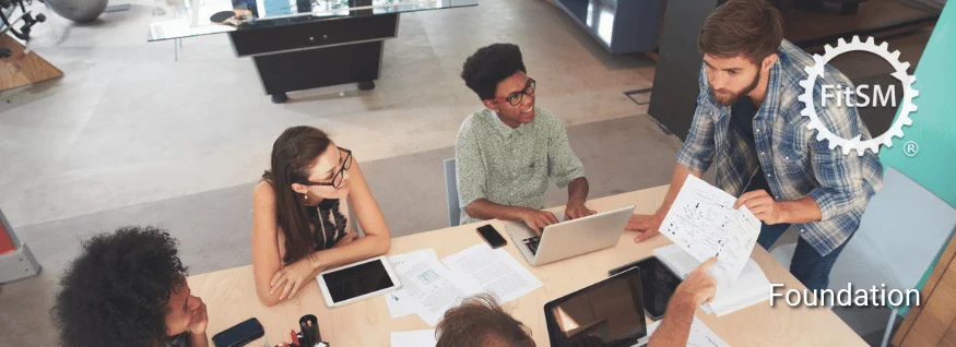 Personengruppe im Gespräch mit Unterlagen und Laptops, oben rechts FitSM-Symbol – Darstellung für FitSM Foundation Training als Einstieg ins IT-Service-Management.