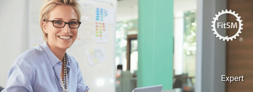 Lächelnde Person mit Brille vor Whiteboard mit Diagrammen, oben rechts FitSM-Symbol – Darstellung für FitSM Expert Training im Bereich IT-Service-Management.