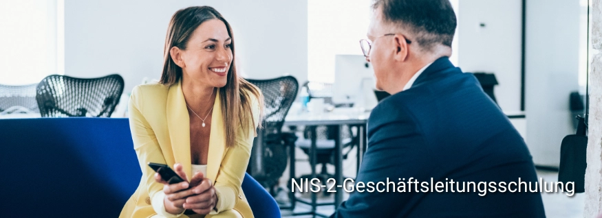 Zwei Personen im Gespräch in moderner Büroatmosphäre, eine davon mit Smartphone, eingeblendeter Text „NIS2 für Geschäftsführung und Management“ – Darstellung einer zielgruppenspezifischen Schulung zur NIS2-Richtlinie.