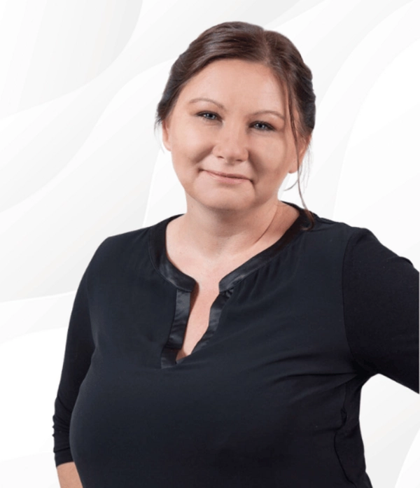 Patrycja Schrenk, Trainerin und Geschäftsführerin der PSW TRAINING, lächelt in schwarzer Kleidung vor hellem Hintergrund.