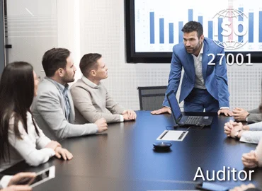 Personengruppe im Konferenzraum mit Präsentation im Hintergrund, ISO 27001-Siegel eingeblendet – Darstellung für ISO 27001 Auditor Training im Bereich Informationssicherheit.