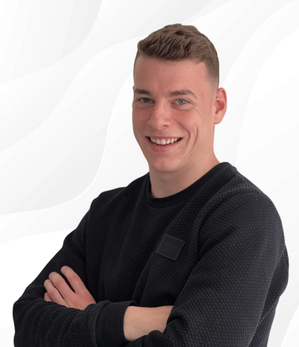 Silas Holzhauer, Kundenbetreuer bei PSW TRAINING, lächelt mit verschränkten Armen in schwarzer Kleidung vor hellem Hintergrund.