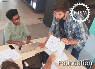 Personengruppe im Gespräch mit Unterlagen und Laptops, oben rechts FitSM-Symbol – Darstellung für FitSM Foundation Training als Einstieg ins IT-Service-Management.