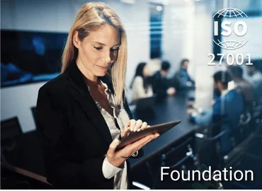 Person mit Tablet in moderner Büroumgebung, im Hintergrund ISO 27001-Siegel – Darstellung für ISO 27001 Foundation Training im Bereich Informationssicherheitsmanagement.