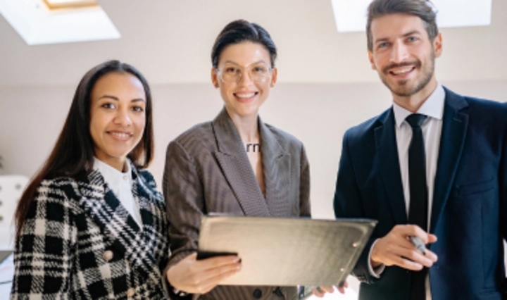 Drei Auditoren im Büro betrachten gemeinsam ein Tablet zur Dokumentenprüfung im Rahmen eines internen Audits nach ISO 19011.