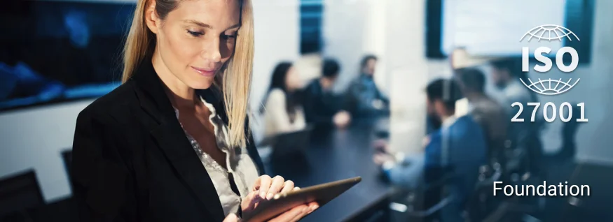 Person mit Tablet in moderner Büroumgebung, im Hintergrund ISO 27001-Siegel – Darstellung für ISO 27001 Foundation Training im Bereich Informationssicherheitsmanagement.